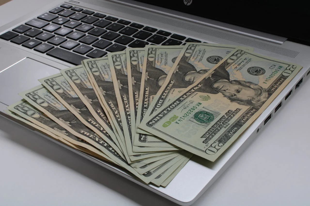 Billetes junto a computador | Inversiones