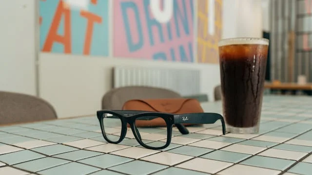 Gafas o lentes Rayban de Meta sobre una mesa junto a un te helado en una cafeteria