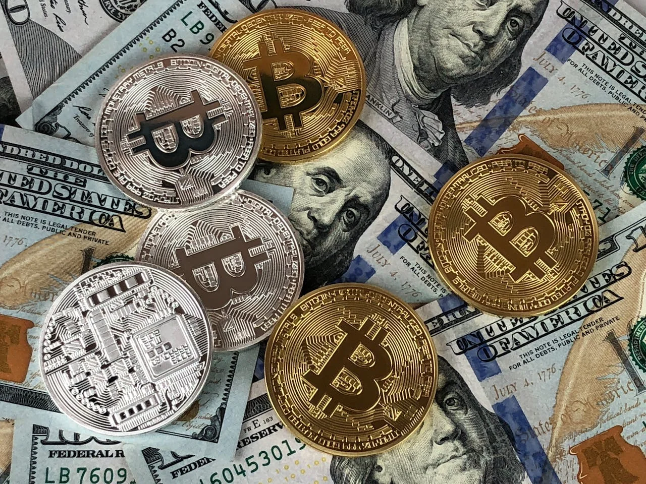 Monedas de Bitcoin sobre dólares en una mesa
